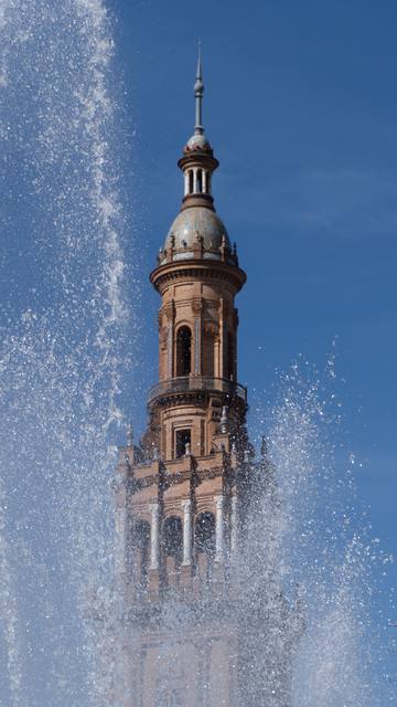 ornate cathedral spire behind a fountain