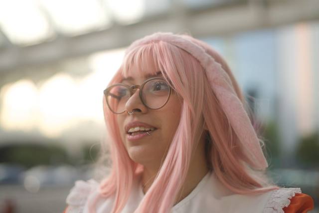 cosplayer with pink hair and glasses